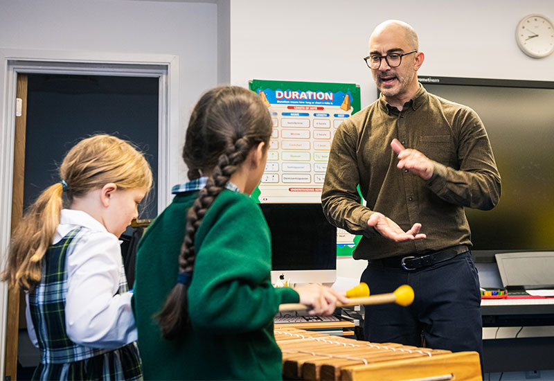 Music teacher teaching children in class