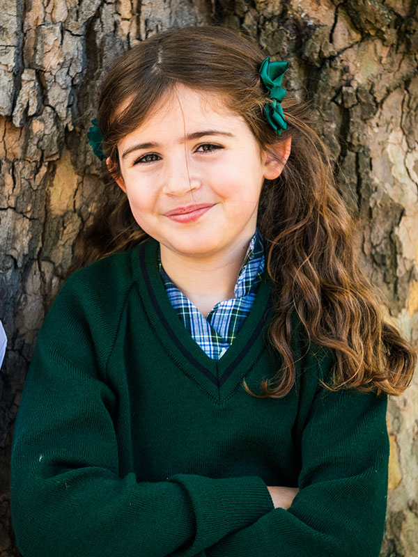 Girl learning against tree