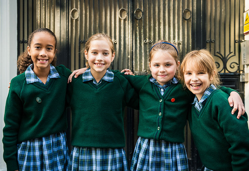 Pupils standing outside the front of Queens College Prep school